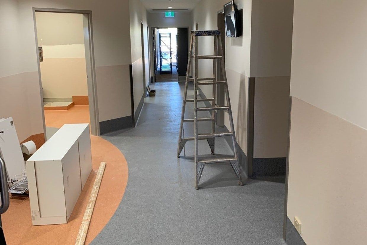 Hallway With a Ladder and Cabinet, Grey and Orange Flooring — Ozwide Flooring In Ciccone, NT