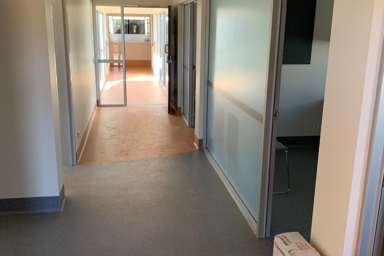 Hallway With Grey and Orange Floors, Frosted Glass Wall, and Open Doorway  — Ozwide Flooring In Ciccone, NT