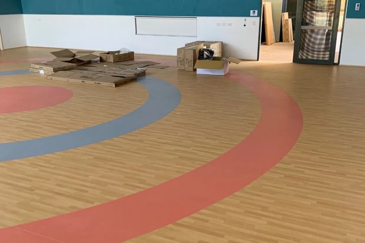 Wooden Floor With Concentric Circles in Pink, Blue, and Tan — Ozwide Flooring In Ciccone, NT