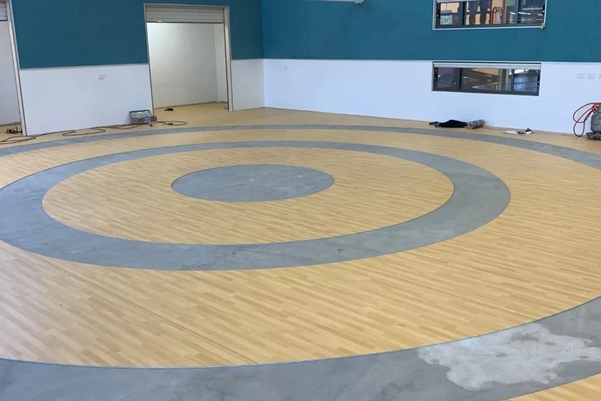Circular Wrestling Mat With Concentric Rings in a Room With Blue and White Walls — Ozwide Flooring In Ciccone, NT