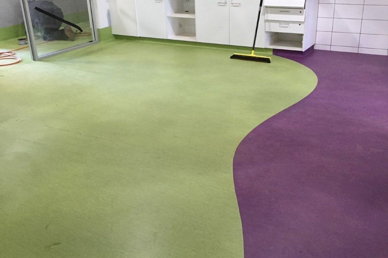 Green and Purple Flooring With a Wavy Edge in a Room With White Cabinets — Ozwide Flooring In Ciccone, NT
