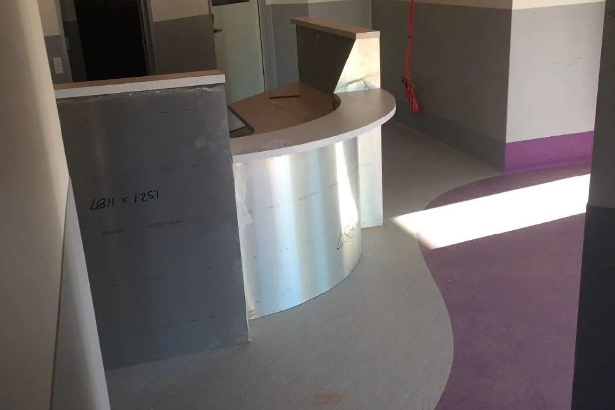 Curved Reception Desk in a Room With Light Grey Walls — Ozwide Flooring In Ciccone, NT