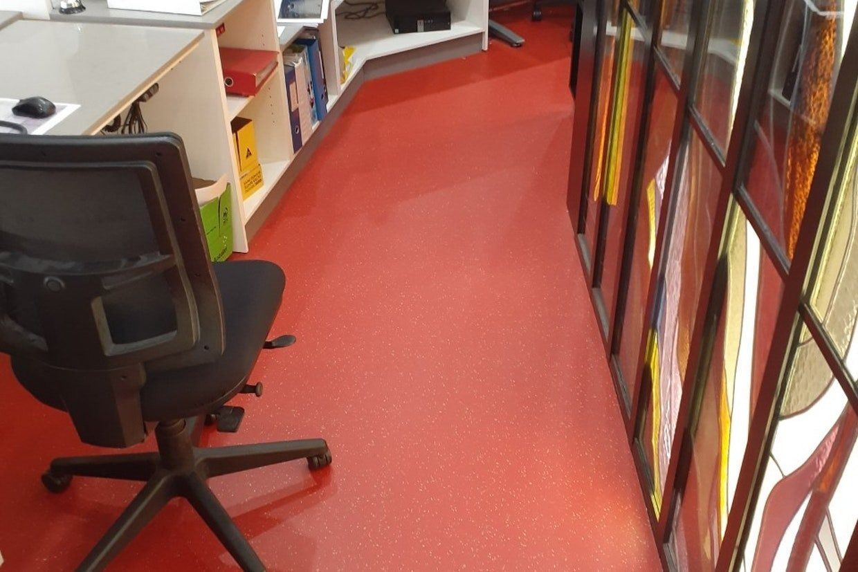 Office Interior: Red Floor, Black Desk Chair, File Shelves, and Documents — Ozwide Flooring In Ciccone, NT