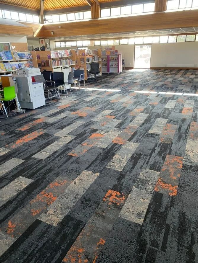 Library Interior With Patterned Carpet, Bookshelves, and Large Windows — Ozwide Flooring In Ciccone, NT