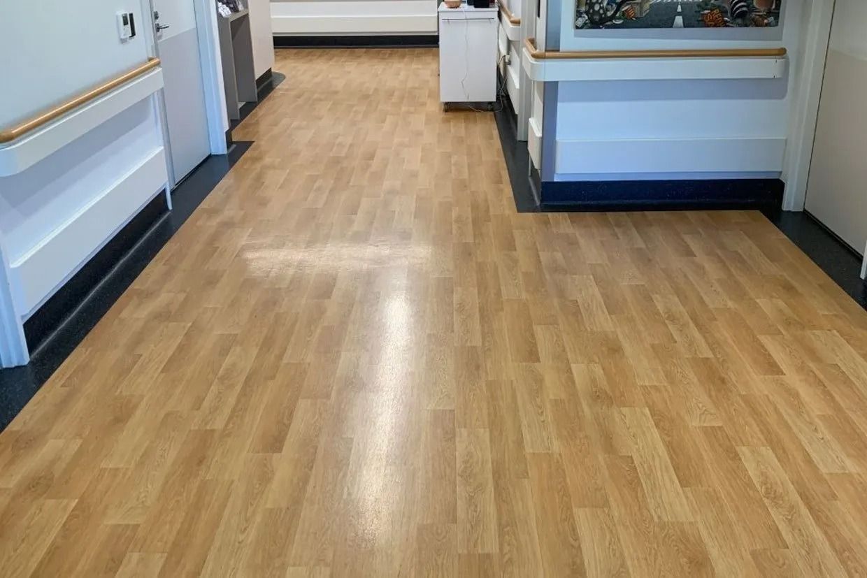 Hallway With Wood-look Flooring and White Walls, Likely a Medical Facility — Ozwide Flooring In Ciccone, NT