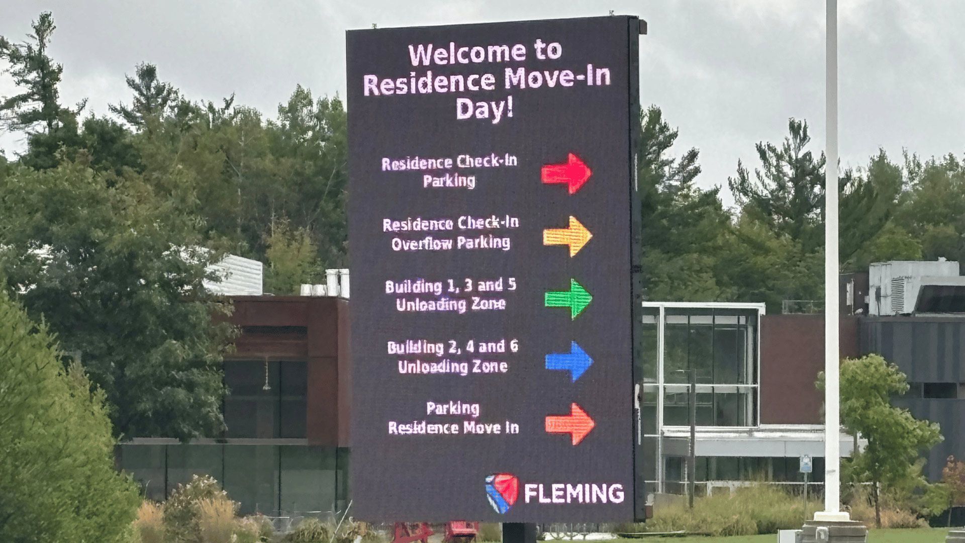 Sign for Residence Move-In Day with colorful directional arrows outside a Fleming building.