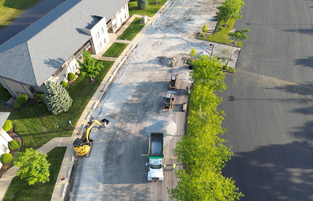 An aerial view of a parking lot with a truck parked in front of a building.
