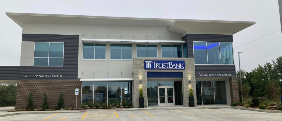 A large building with a lot of windows and a blue sign that says true bank.