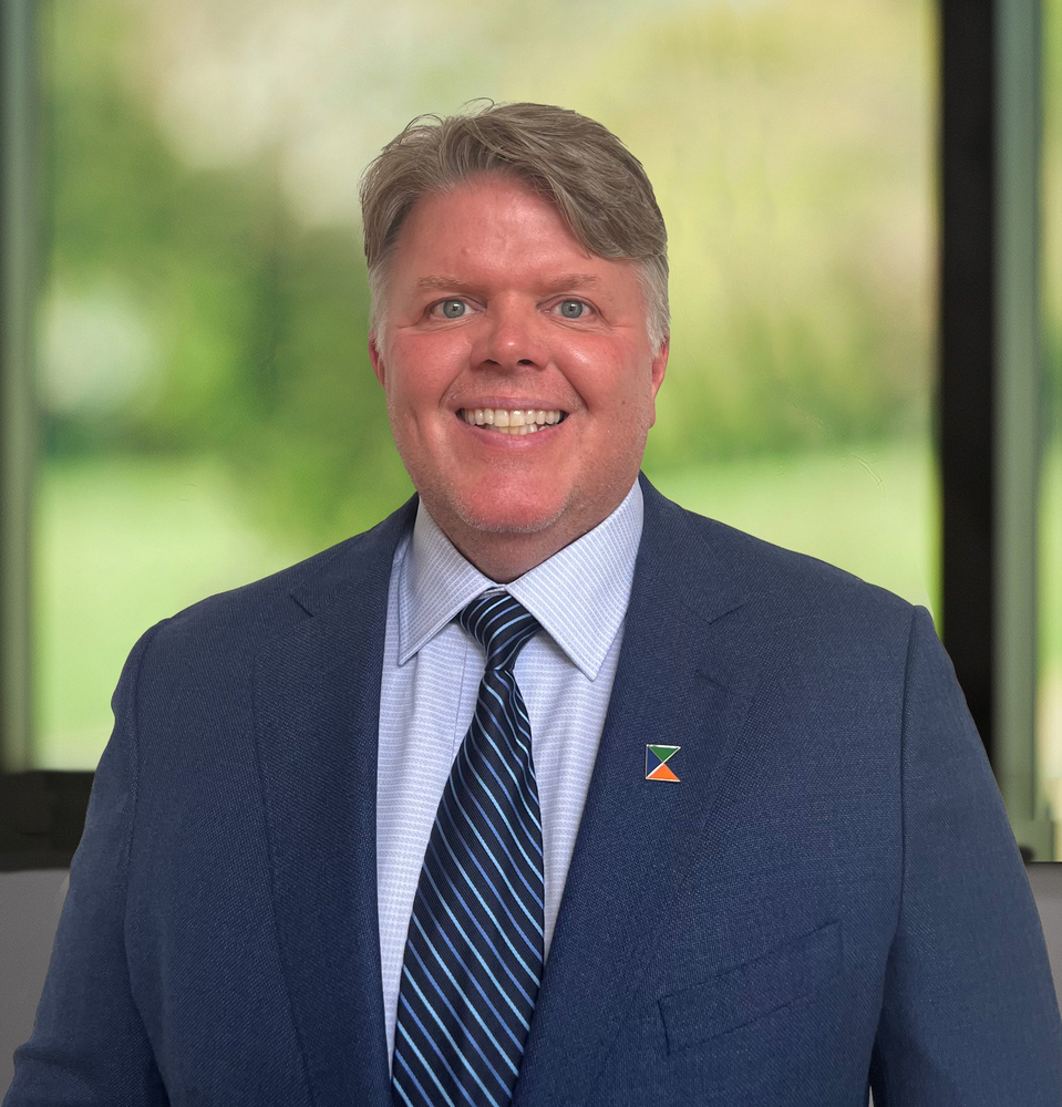 A man in a suit and tie is smiling for the camera.
