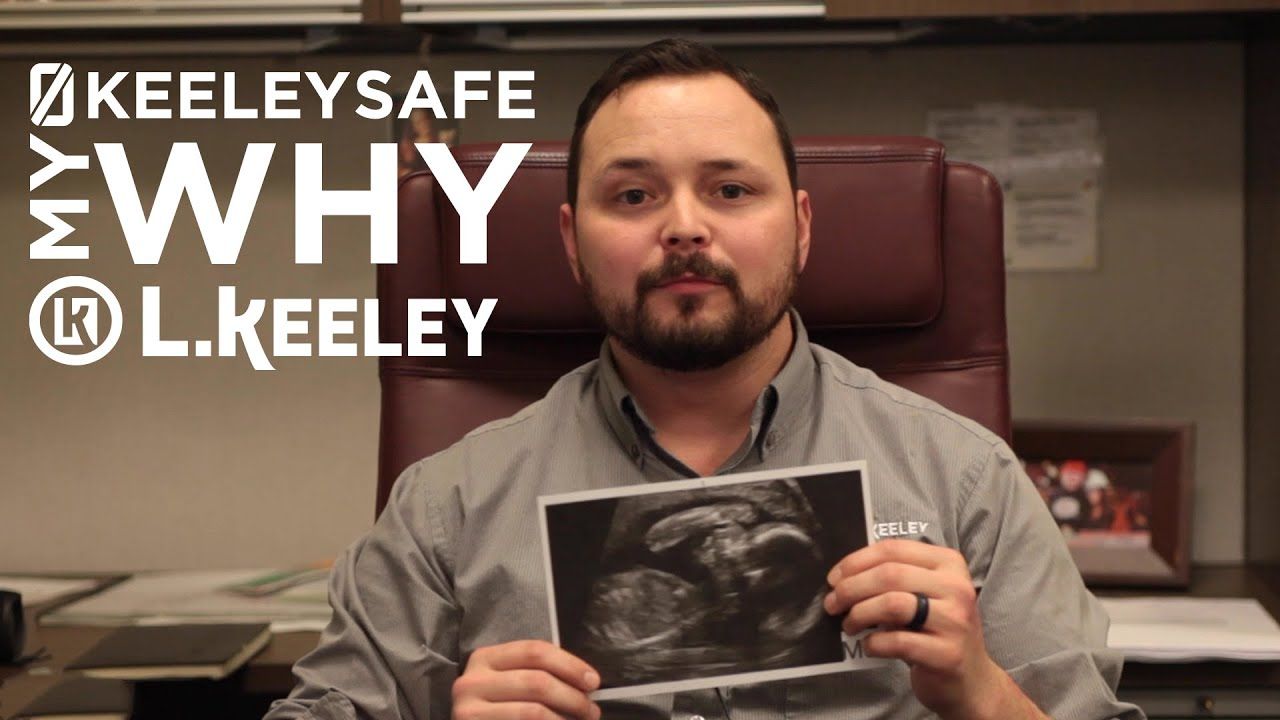 A man is holding a picture of a baby in his hands.