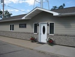 Gray building with a white door, windows, and