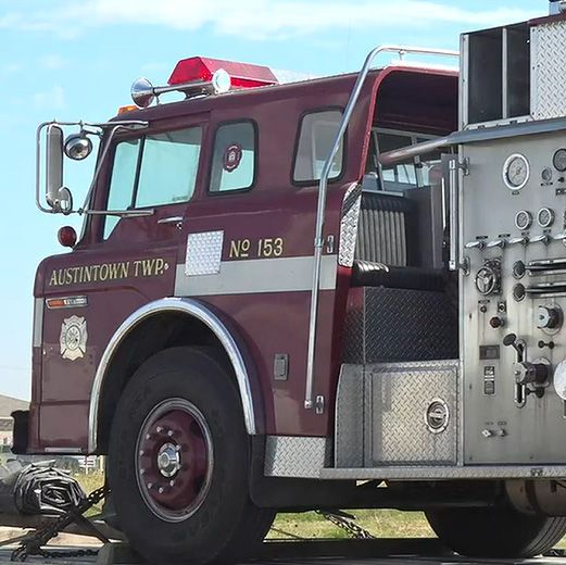 Maroon fire truck with chrome details parked outdoors, side view