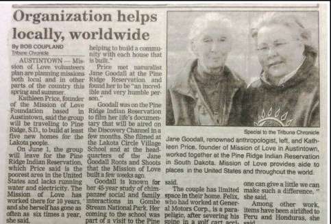 Newspaper article with a photo of two smiling people standing outdoors.