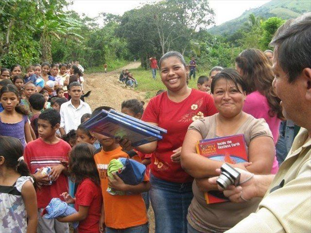 Julio is making so many children happy by giving them a donated book. Look at the happiness that a