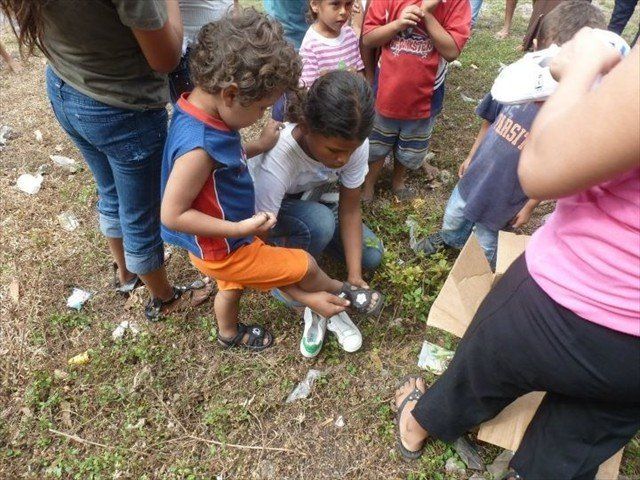A Honduran Mom fitting her child with donations of shoes from our Mission of Love.