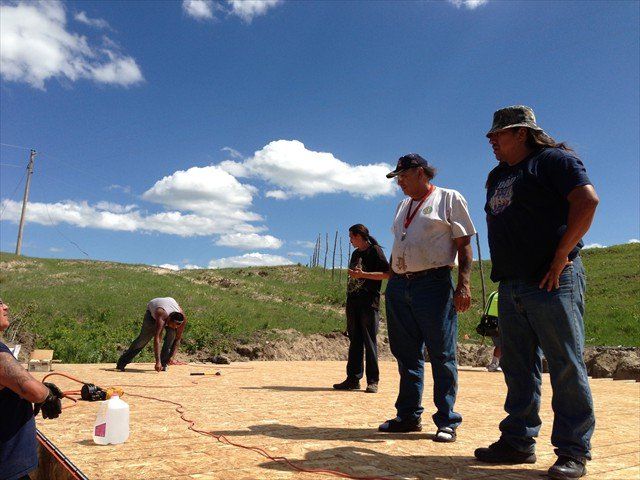 A group of men are standing in a field at Pine Ridge Reservation