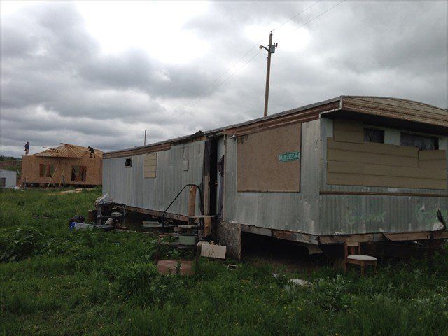 A trailer is sitting in the middle of a grassy field at Pine Ridge Reservation