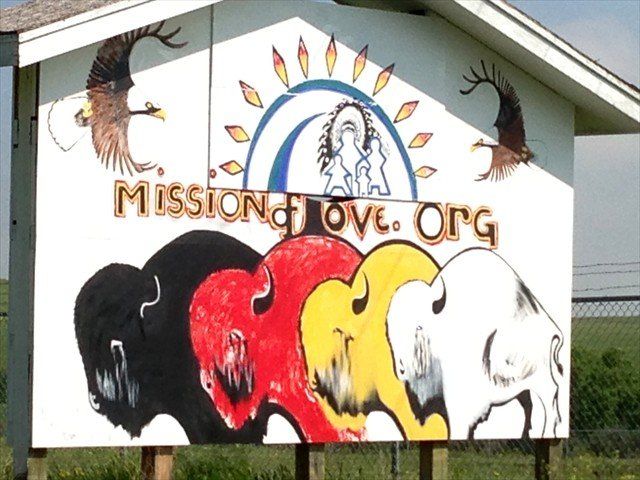 Mission of Love.org mural with buffalos and rainbow on a building exterior