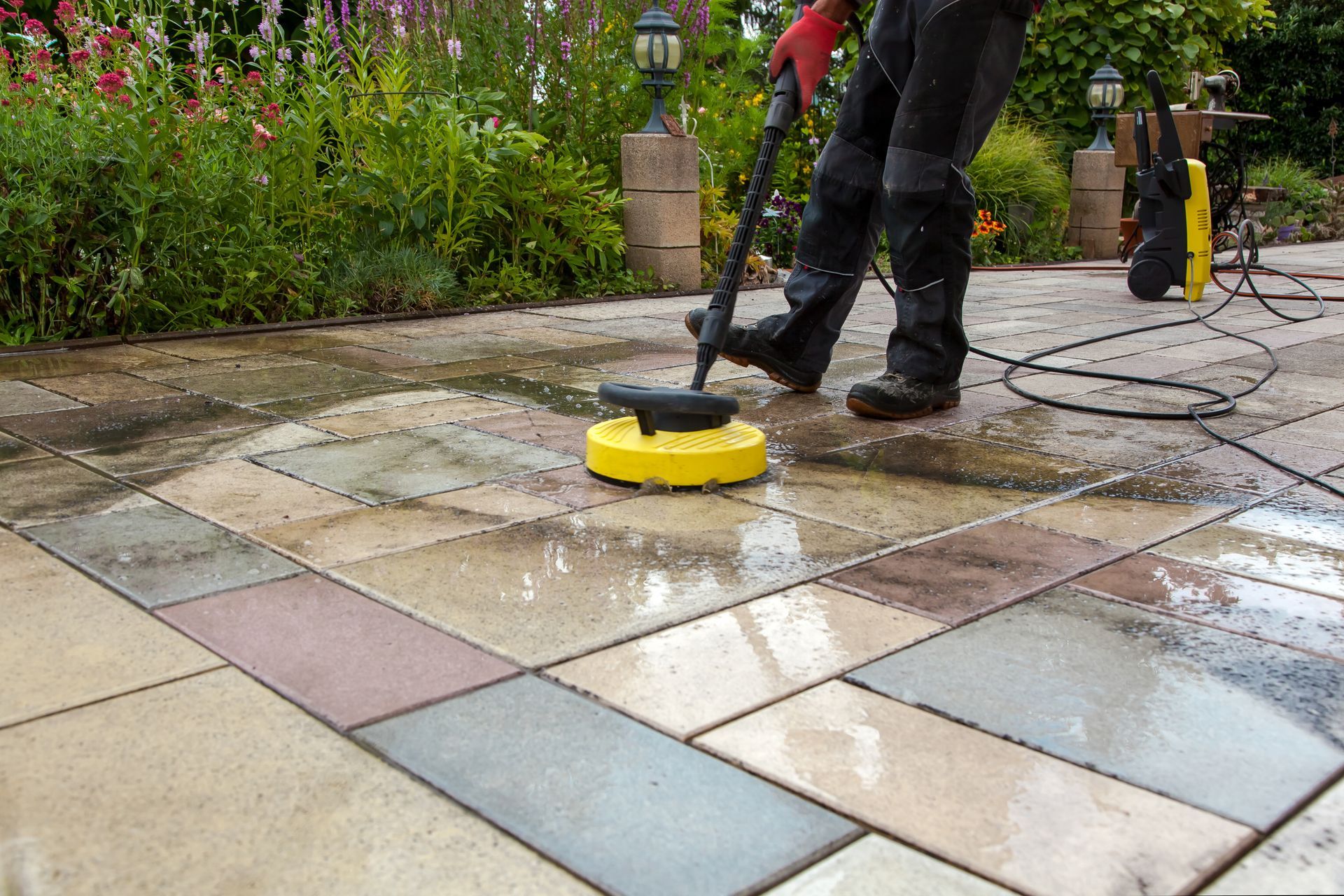 Person Power Washing a Stone Patio with A Yellow Cleaning Head — Tampa, FL — A&A's Complete Services, Inc.