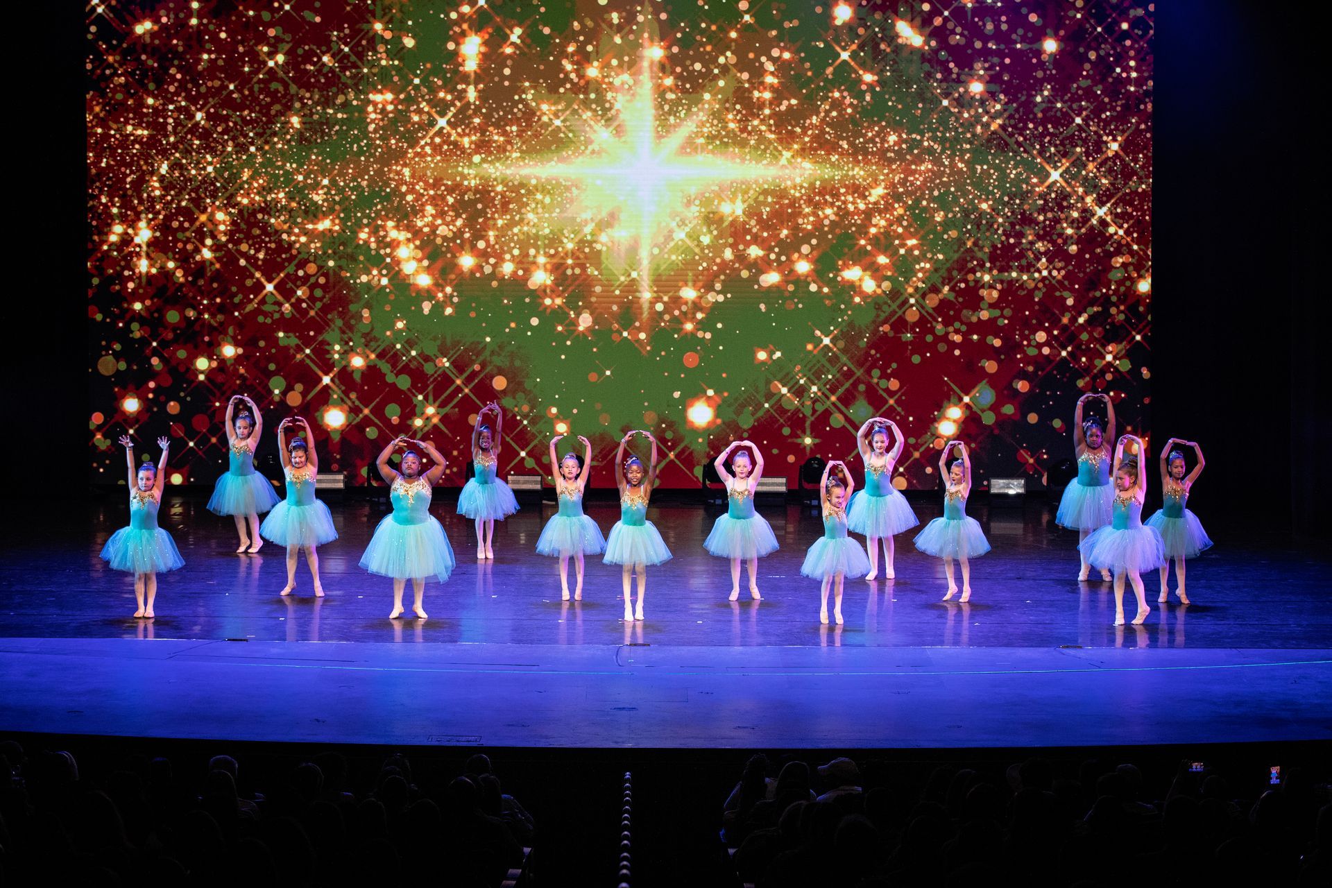 Young ballerinas in pink ballet outfits are stretching at the barre in a dance studio. Young ballerinas in pink ballet outfits are stretching at the barre in a dance studio.