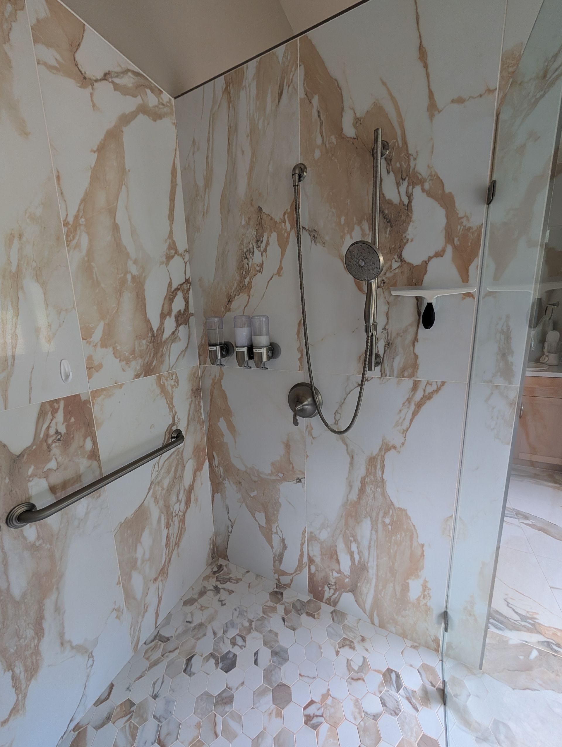 Damaged bathroom walls with peeling plaster, exposed pipes, and unfinished plumbing fixtures.