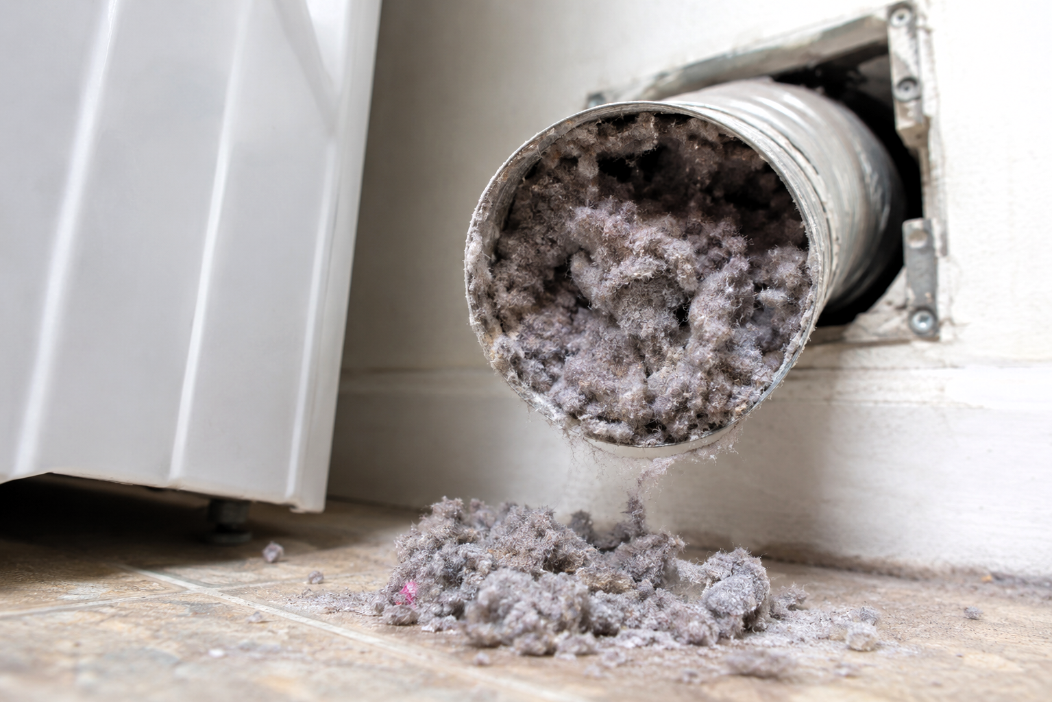Close-up of a dangerous lint blockage inside a dryer vent pipe.