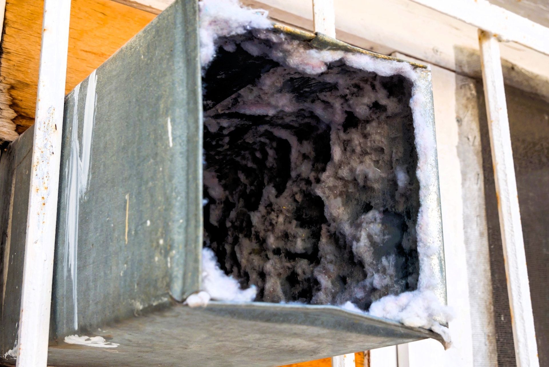 Lint-clogged air duct with heavy debris buildup