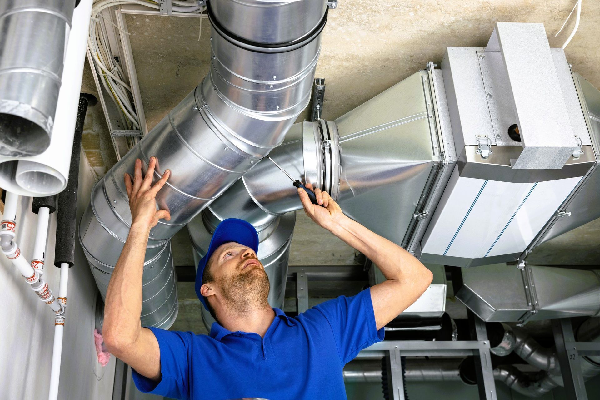 HVAC technician repairing ceiling ductwork