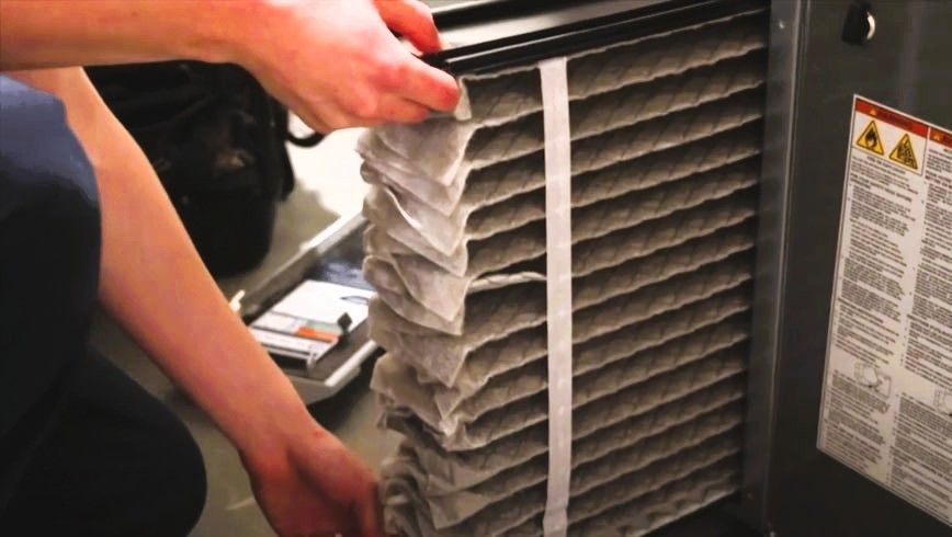 Person replacing a dirty air filter in an HVAC system