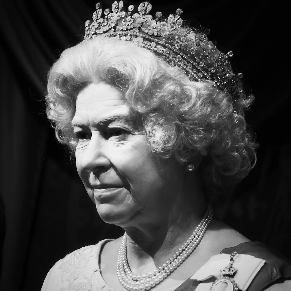 Queen Elizabeth II in a formal portrait, wearing a crown and pearls.