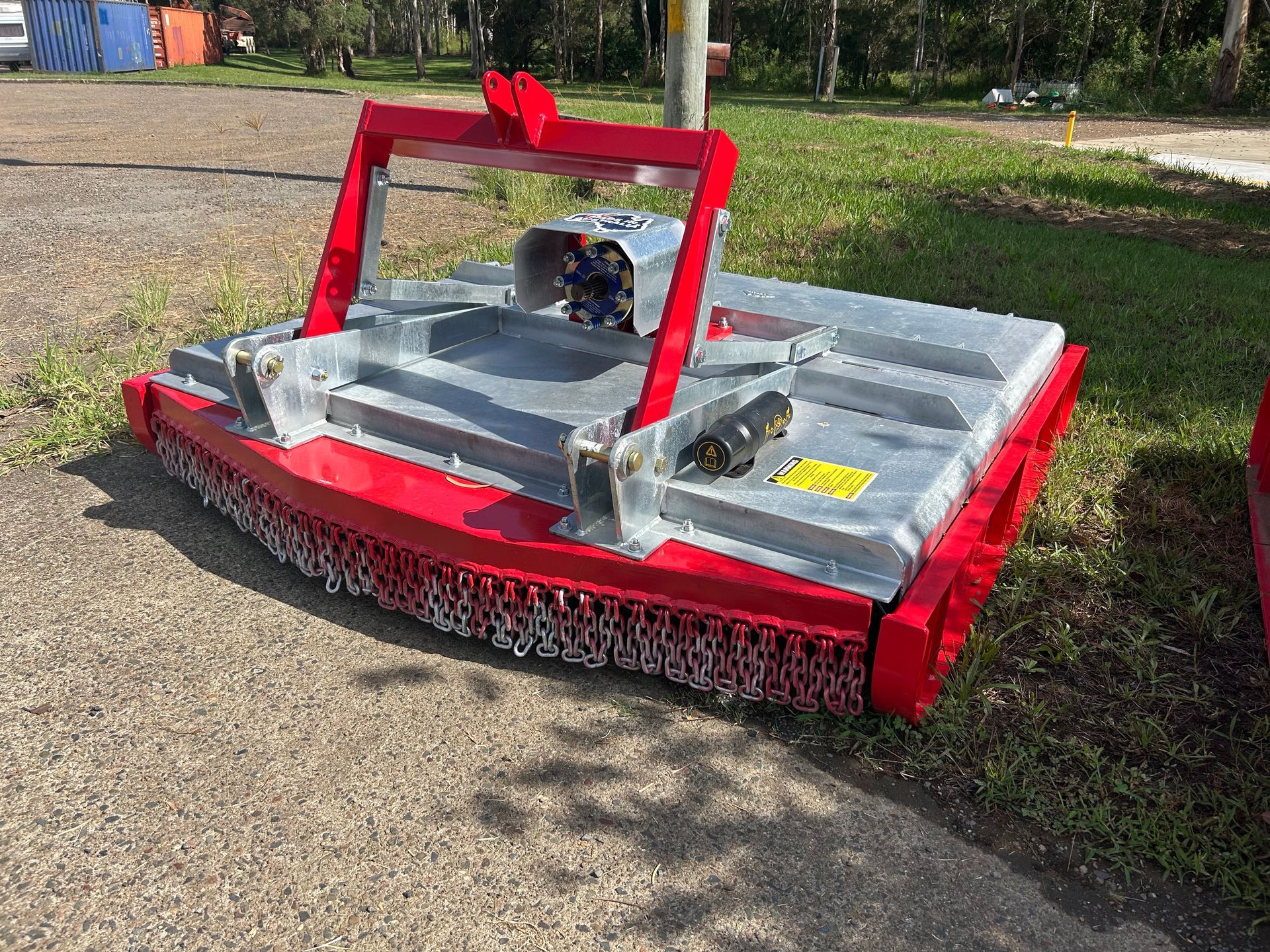 A red and silver lawn mower is parked on the side of the road.— Wingham Farm Machinery in Wingham, NSW