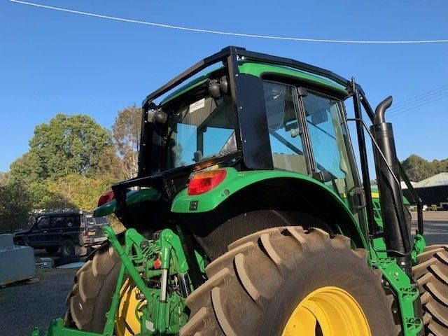 A Green John Deere Tractor is Parked in a Parking Lot — Wingham Farm Machinery in Wingham NSW