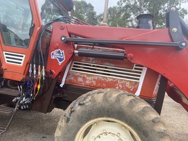 A Red Tractor is Parked in a Dirt Field — Wingham Farm Machinery in Wingham, NSW