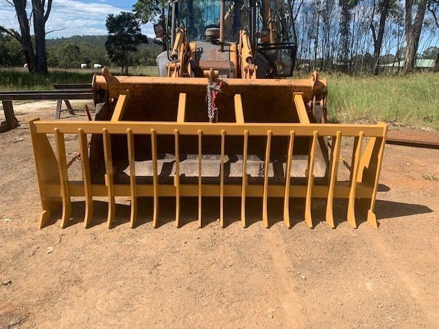 A Yellow Bulldozer is Parked in a Dirt Field — Wingham Farm Machinery in Wingham, NSW