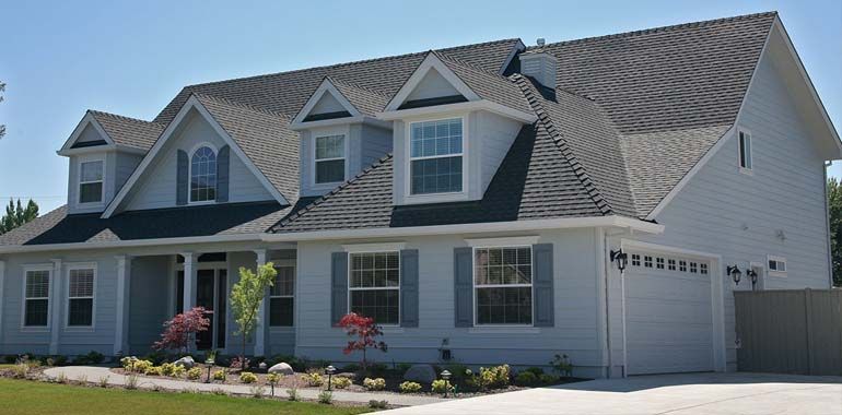 A large white house with a gray roof and black shutters
