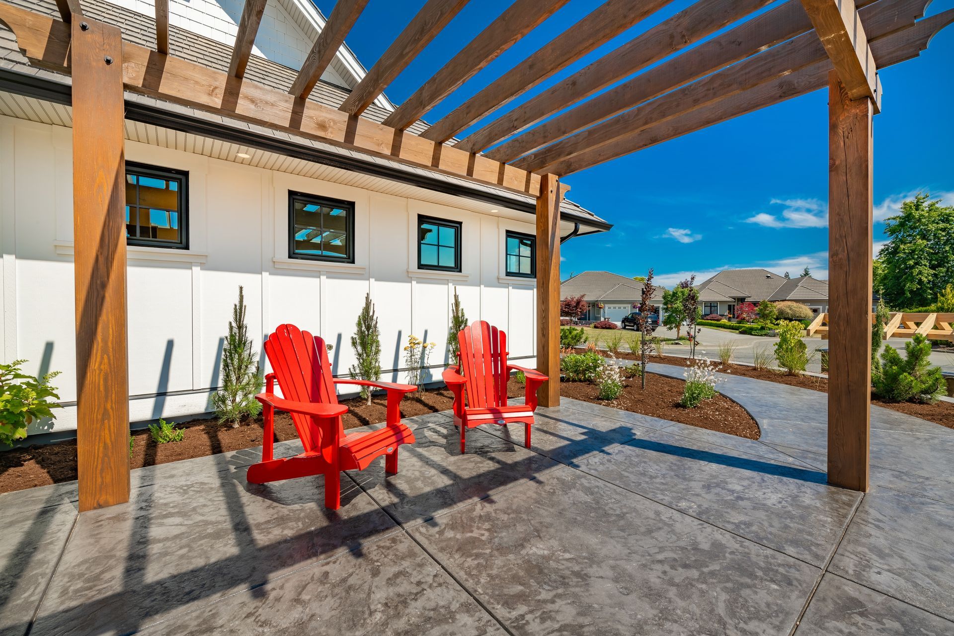 Covered patio with red chairs, stone floor, and mountain view under blue sky