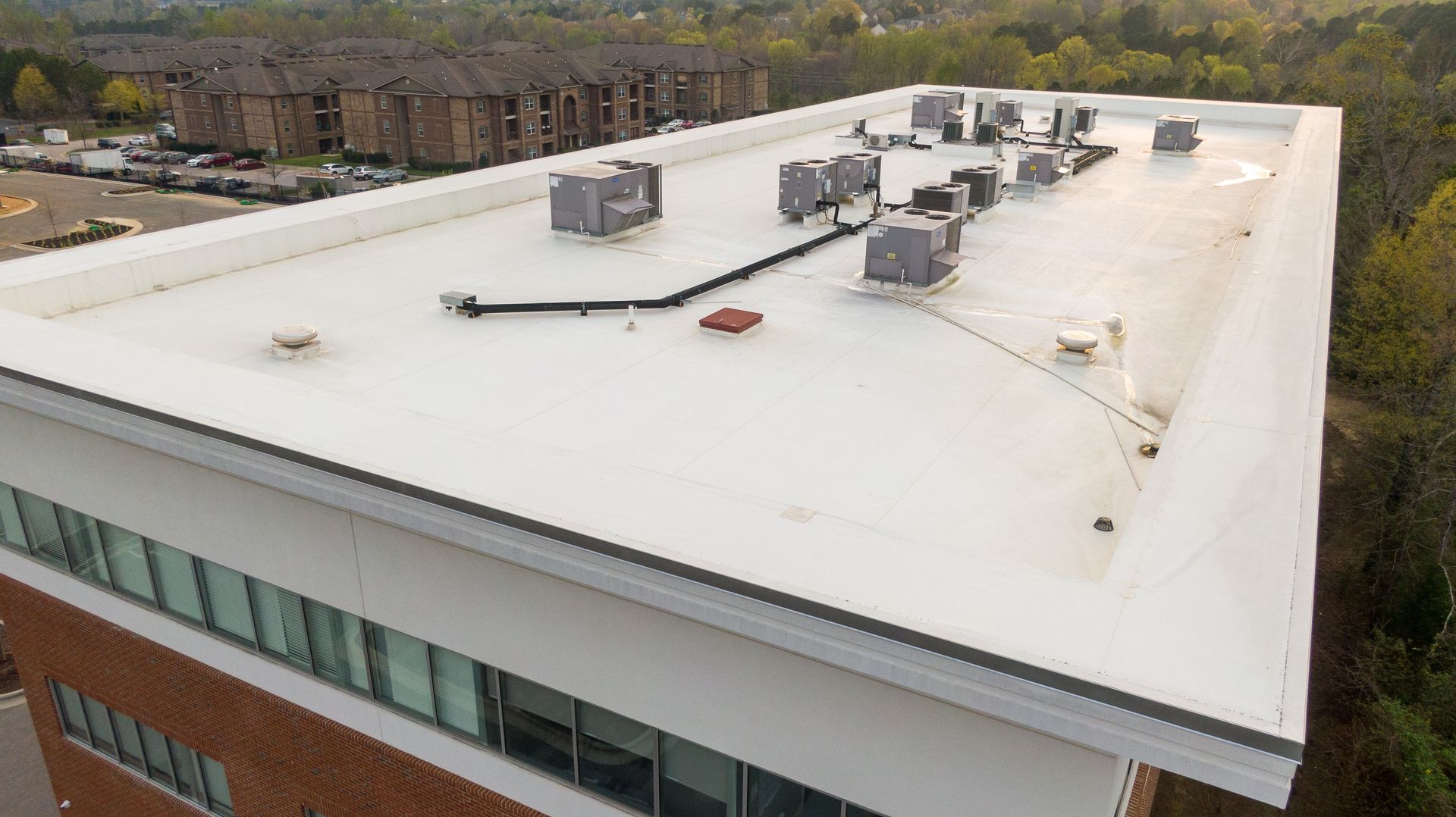 Rooftop HVAC units on a white commercial building, viewed from above.