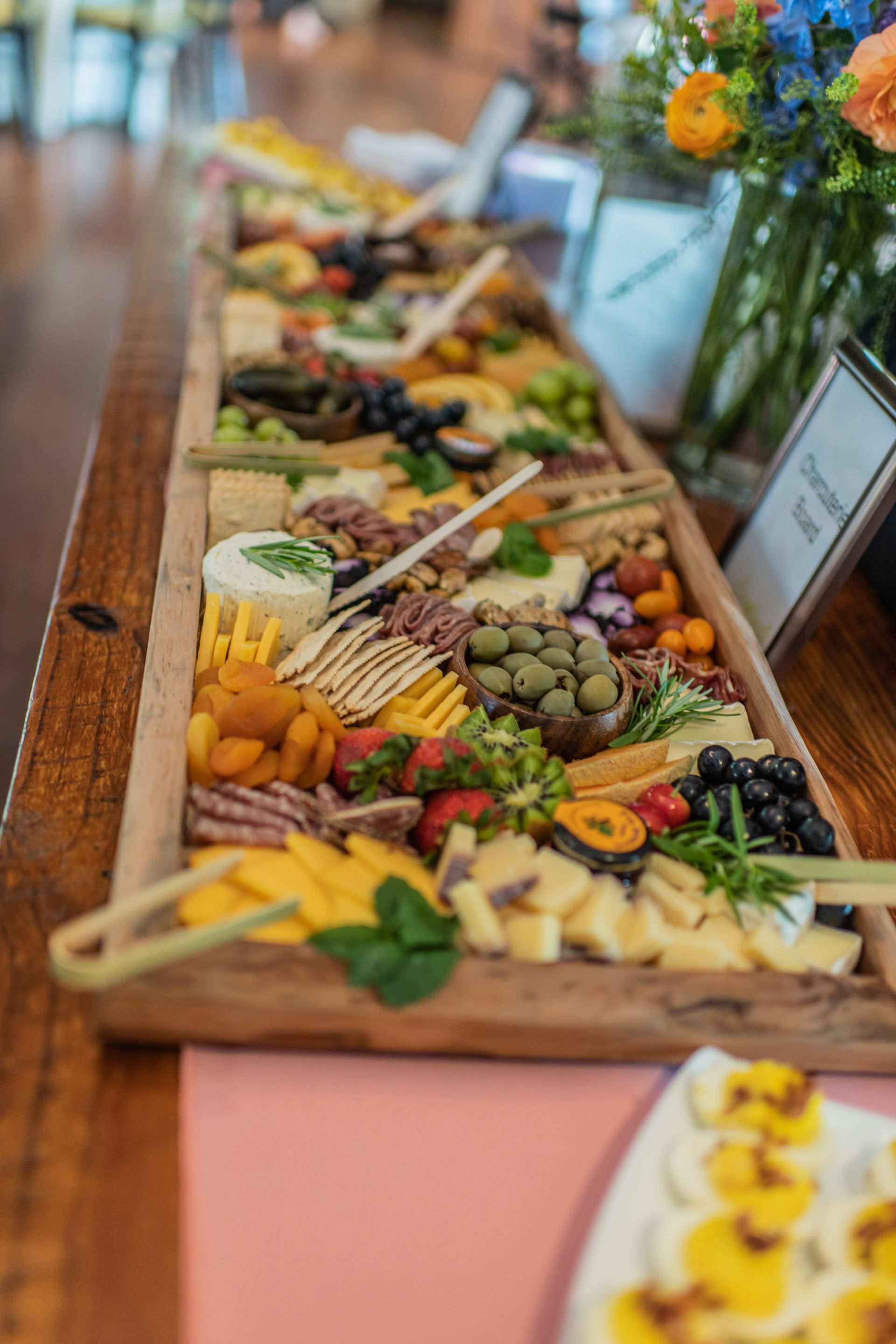 Charcuterie-style appetizer platter with fruit, cheese, and crackers on a buffet table
