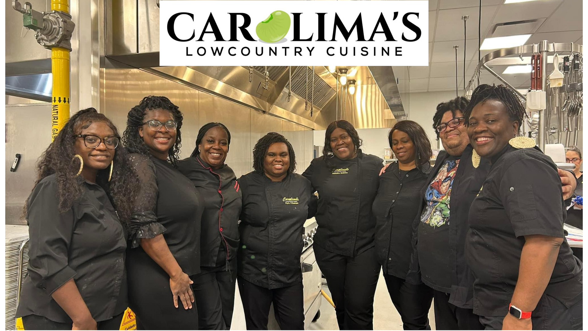 Six staff members in black uniforms pose under the Carolima’s Lowcountry Cuisine sign.