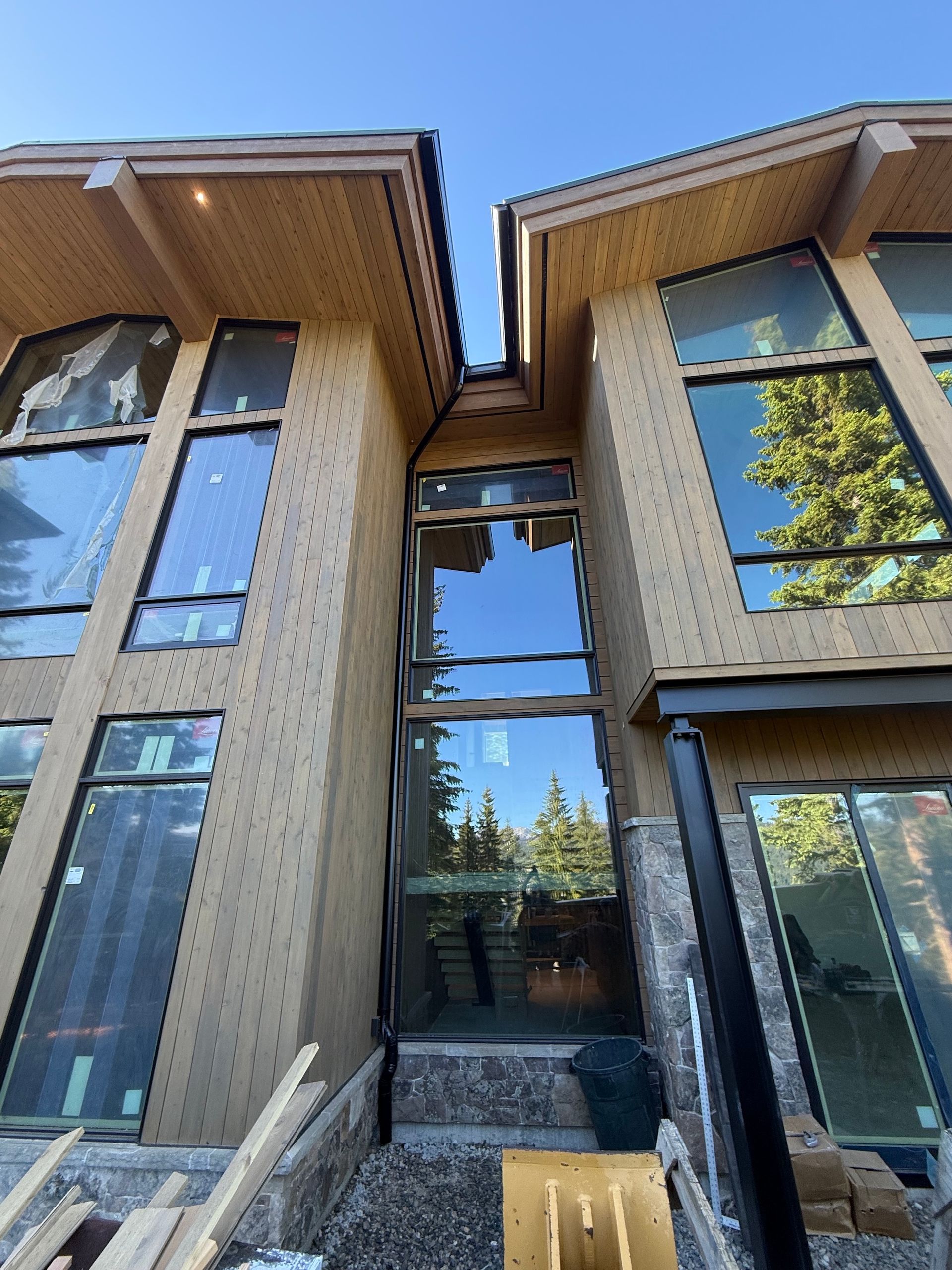 Two-story modern townhouse entrance with large windows, brick siding, and a central glass walkway