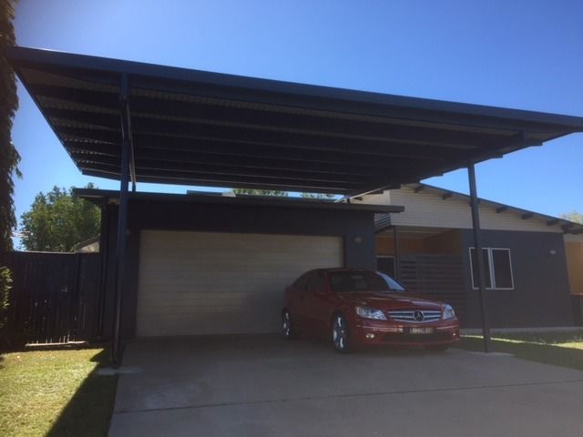 A Red Car is Parked Under a Canopy in Front of a House — Shane Firmin Carpentry Pty Ltd In Mount St John, QLD