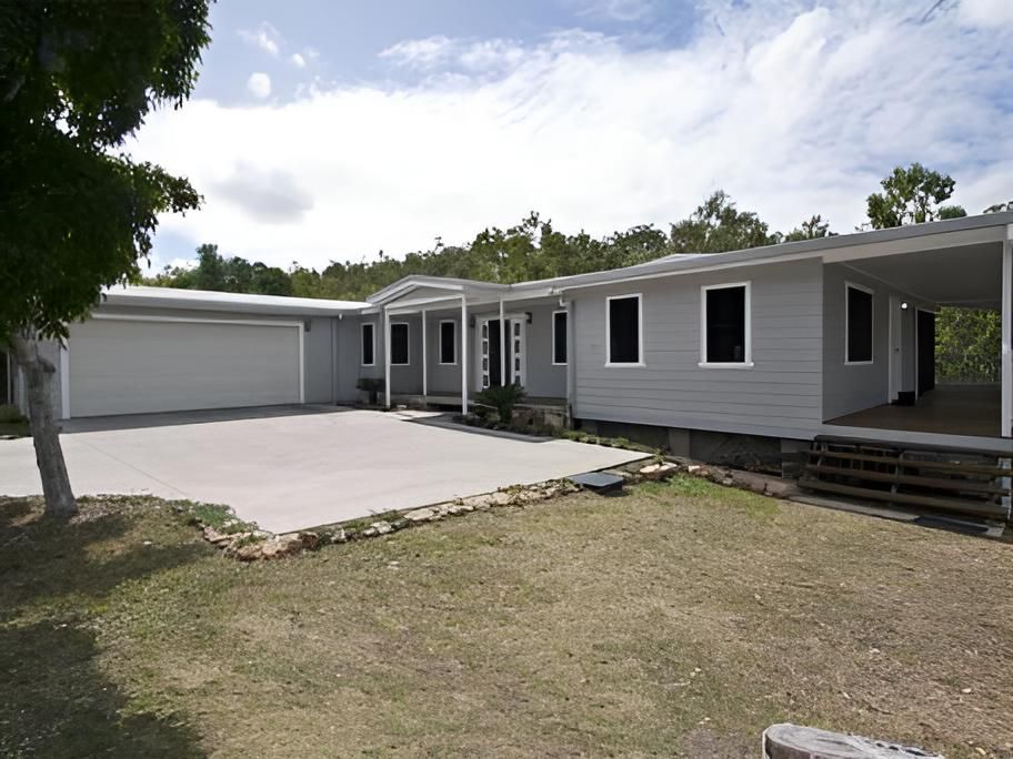 A Large White House With a Garage and Porch — Shane Firmin Carpentry Pty Ltd In Mount St John, QLD