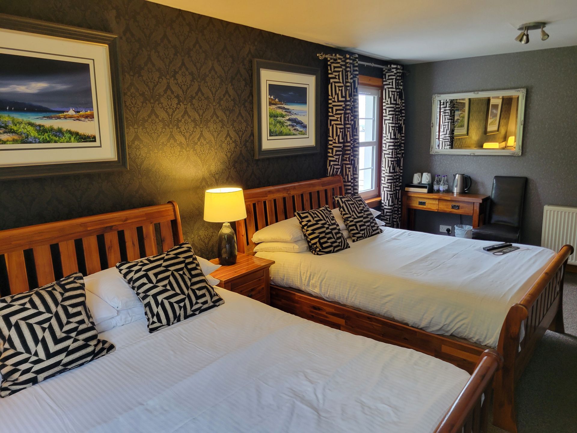 A hotel room with two double beds and a television