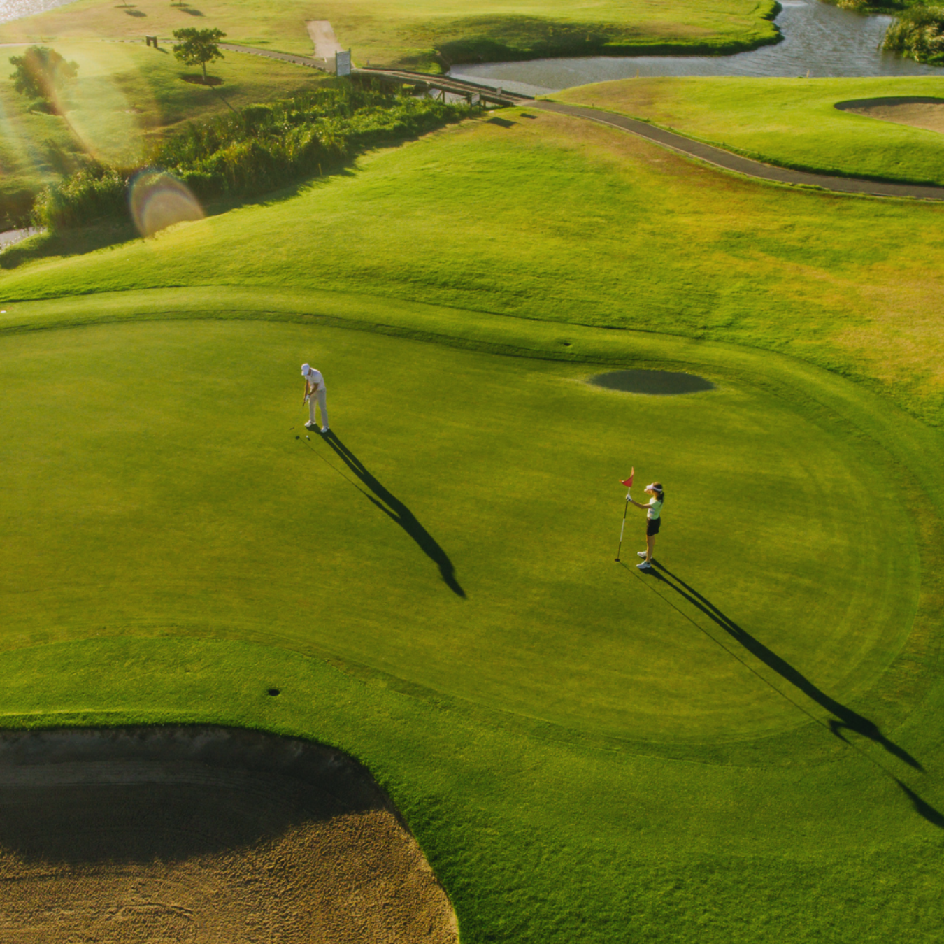 A man is swinging a golf club on a golf course.
