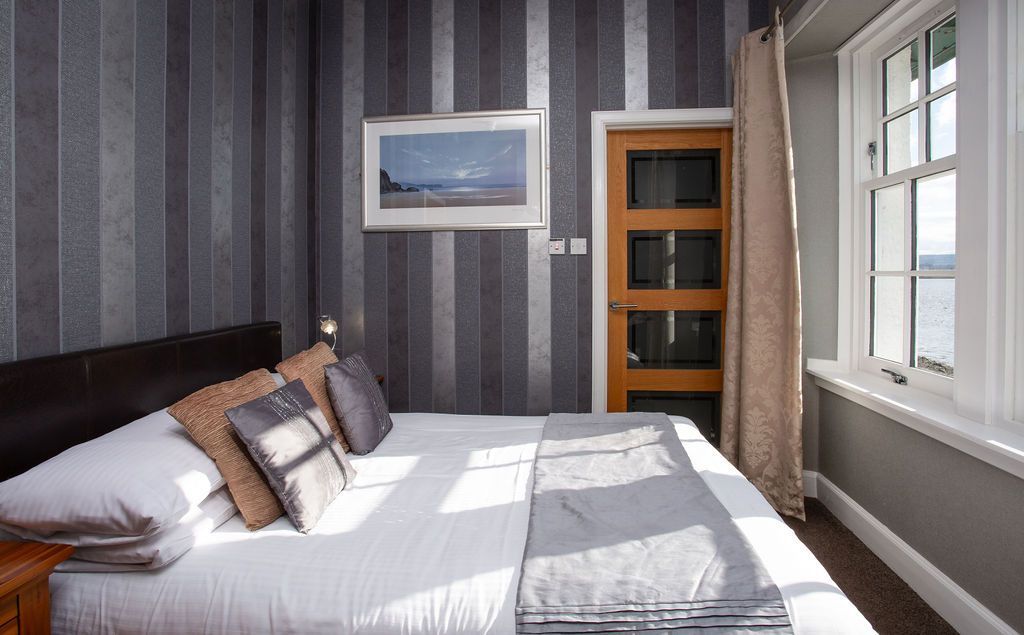 A bedroom with a large bed and a window