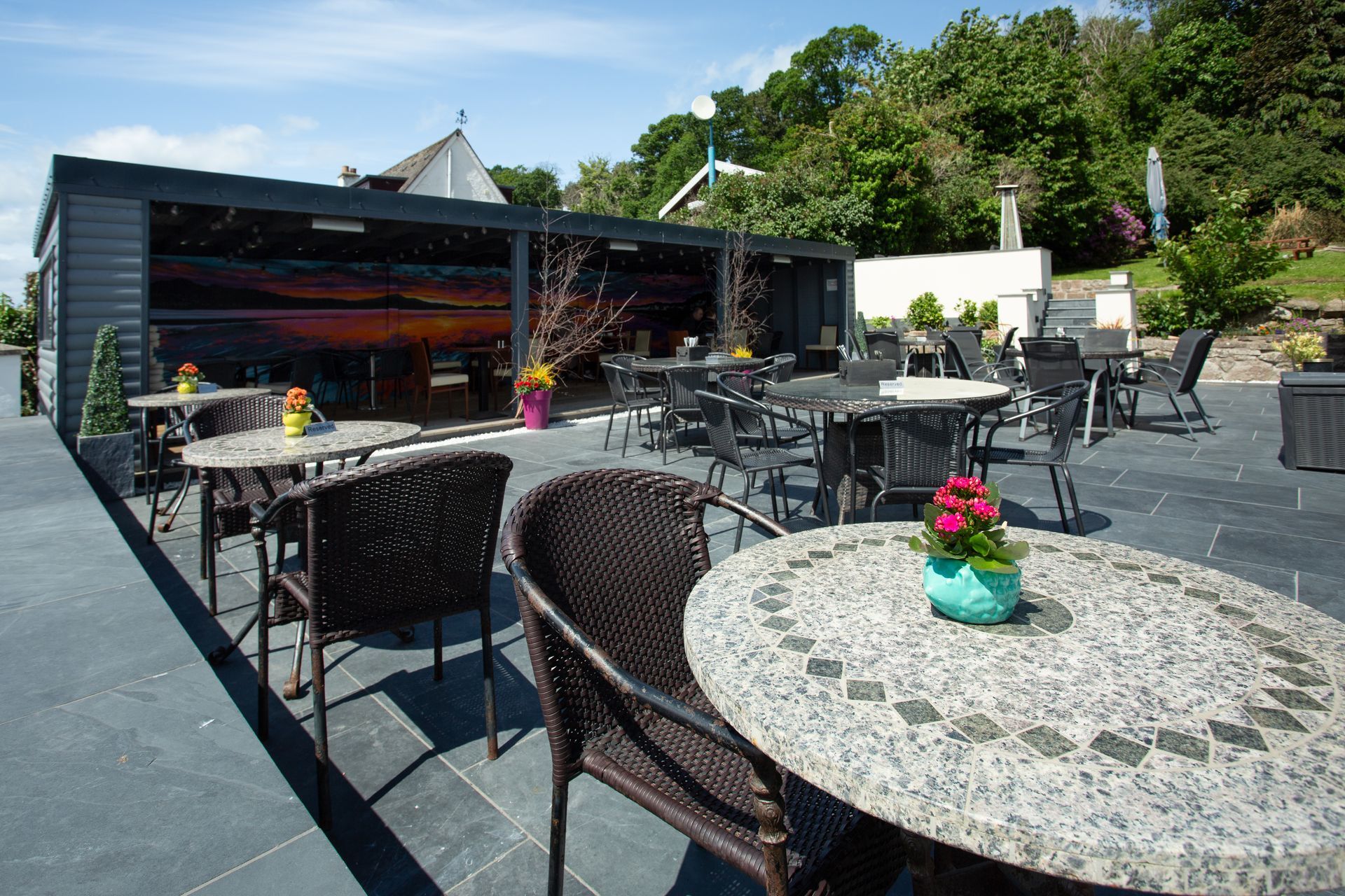 A patio with tables and chairs and a building in the background