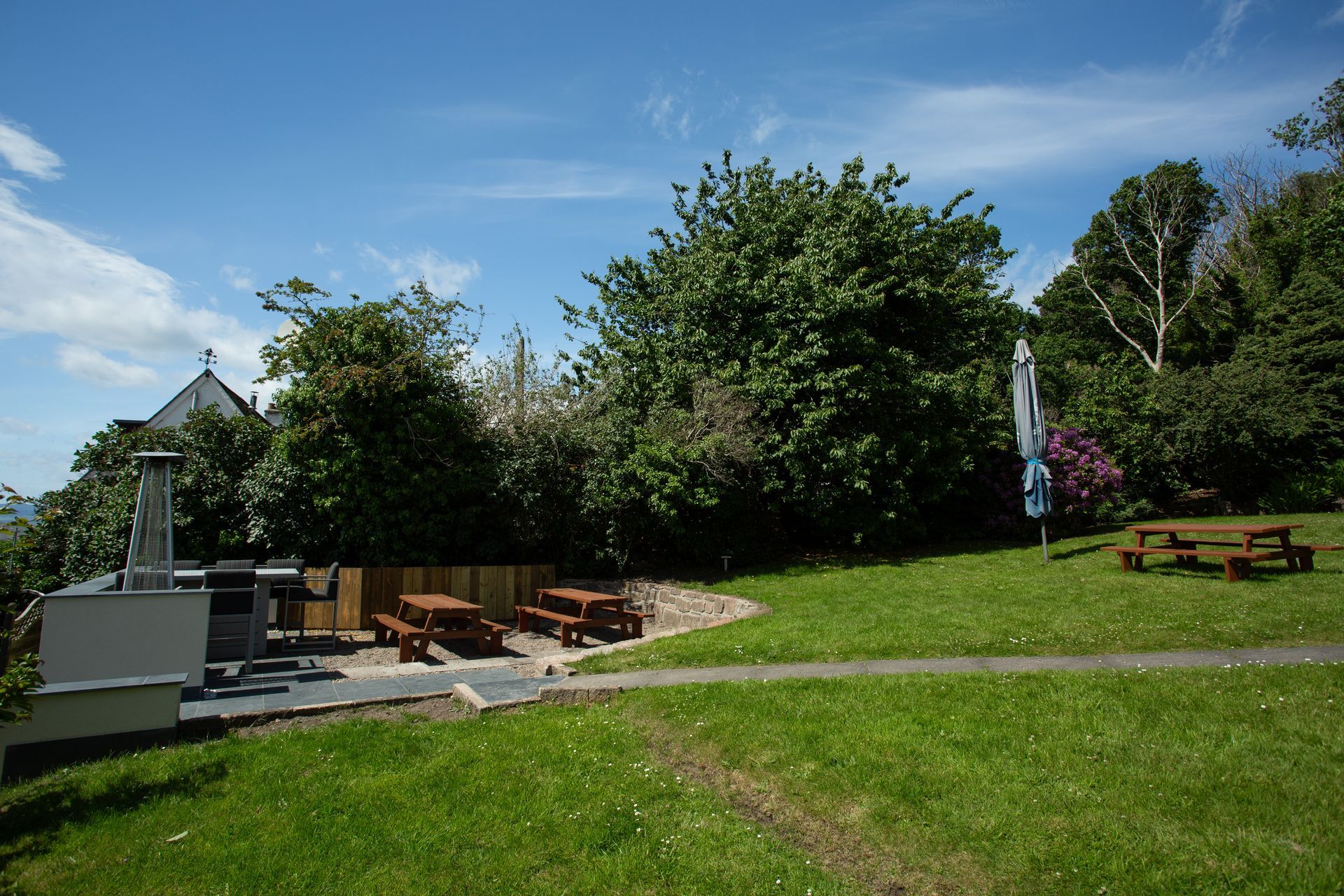 A picnic area with tables and benches in the grass