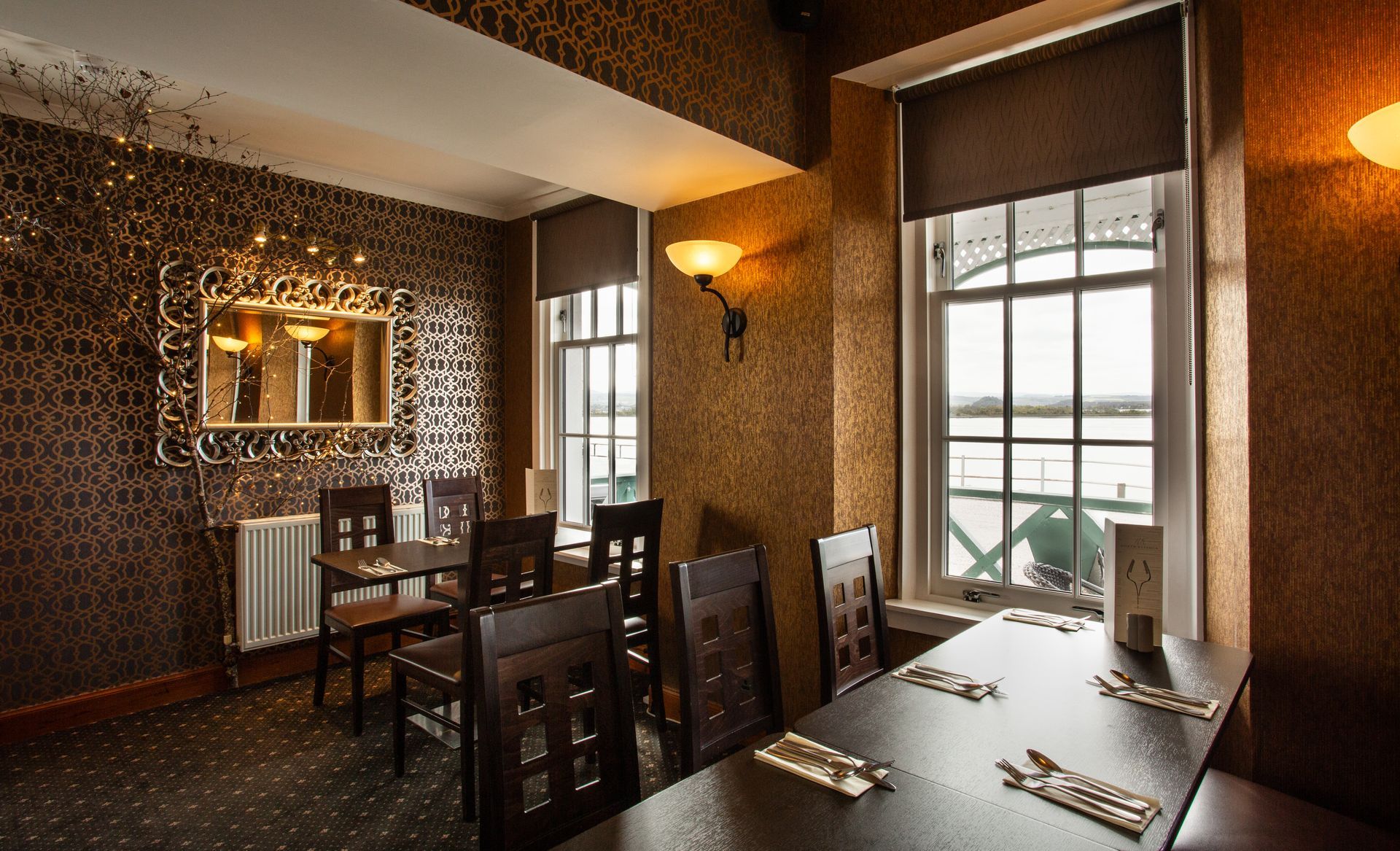 A dining room with tables and chairs and a large window