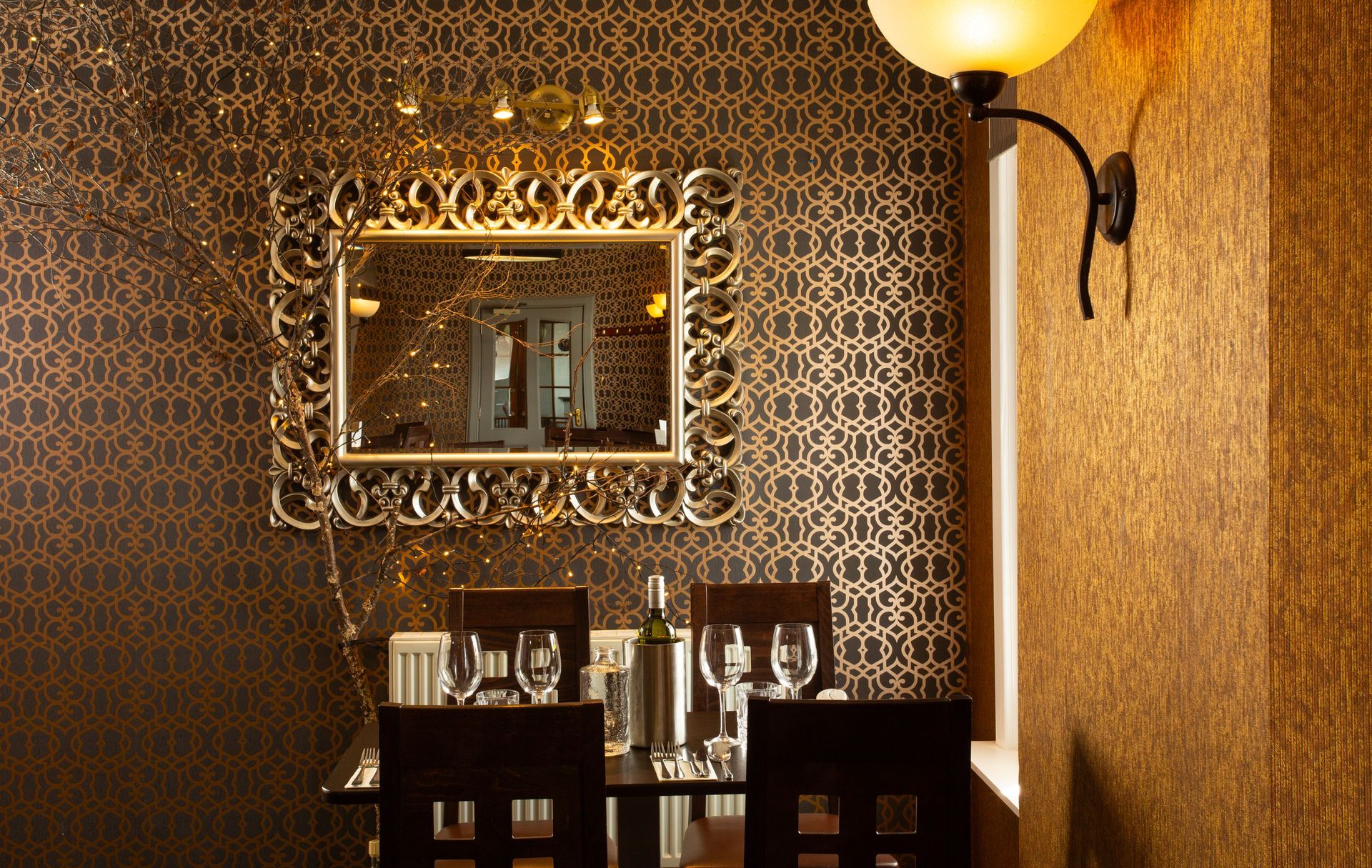 A dining room with a table and chairs and a mirror