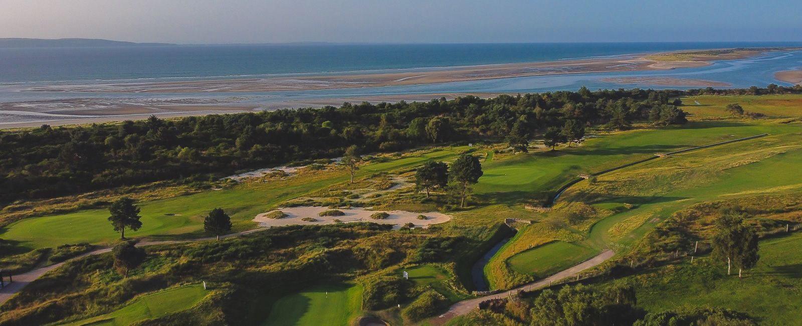 An aerial view of a golf course next to the ocean.